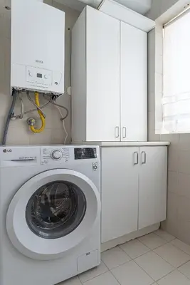 a washing machine in a kitchen with white cabinets at Preciosa Apartment by MP in Vila Nova de Gaia