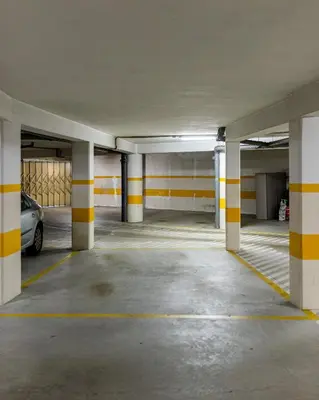 an empty parking garage with yellow and white columns at Preciosa Apartment by MP in Vila Nova de Gaia