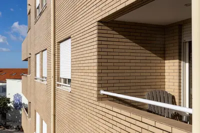 a brick building with a chair on a balcony at Preciosa Apartment by MP in Vila Nova de Gaia