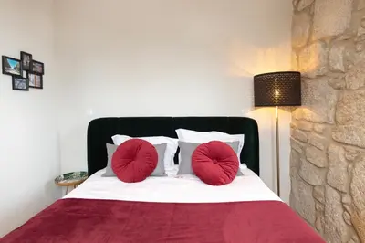 a bedroom with a bed with two red pillows at HM - Porto Blue Pool Apartment in Porto