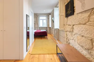 a room with a stone wall and a bedroom at HM - Porto Blue Pool Apartment in Porto