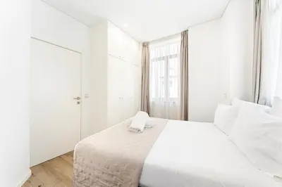 a bed with white sheets and pillows at Alma Invicta Almada in Porto