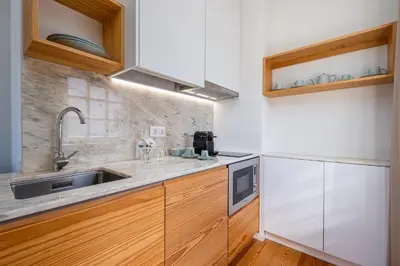 a kitchen with wooden cabinets and a sink at Porta Nobre Boutique Hotel by Aspasios in Porto