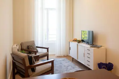 a living room with a tv and a chair and a dresser at bnapartments Cedofeita in Porto