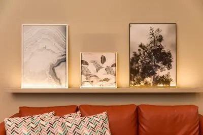 three framed pictures on a shelf above a couch at BRA com Apartments Oporto House 68 in Porto