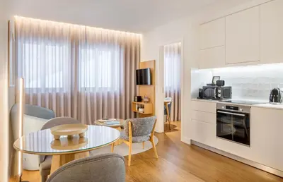 a kitchen and living room with a table and chairs at Catarina Serviced Apartments by HostWise in Porto