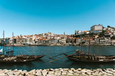 two boats are docked in the water in a city at Douro Eiffel Bridge Amazing View in Vila Nova de Gaia