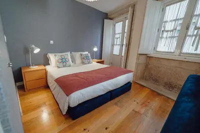 a bedroom with a bed and two windows at River Eyes at Porto apartments in Porto
