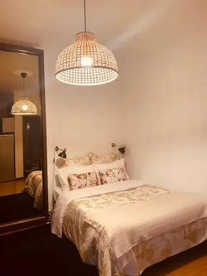 a bedroom with a bed with two lights above it at Apartamento com patio na rua principal da cidade in Porto