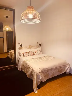 a bedroom with a bed and two lamps and a mirror at Apartamento com patio na rua principal da cidade in Porto