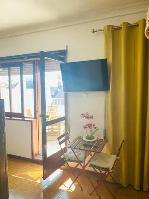 a room with a chair and a table and a window at Apartamento com patio na rua principal da cidade in Porto