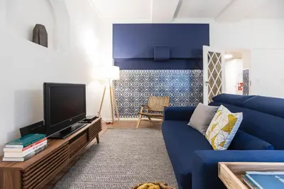 a living room with a blue couch and a tv at Tasteful 2BR Flat in Art District by LovelyStay in Porto