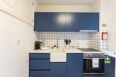 a kitchen with blue cabinets and a sink at Tasteful 2BR Flat in Art District by LovelyStay in Porto
