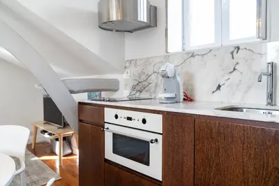 a kitchen with a sink and a stove top oven at Ribeira Loft in Porto