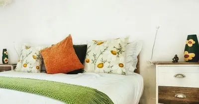 a bedroom with a bed with white sheets and orange pillows at Flores'Old Town - Elegant studio with roomy patio in Porto