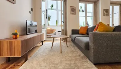 a living room with a couch and a tv at Flores'Old Town - Elegant studio with roomy patio in Porto