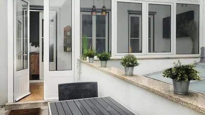 a porch with a bench and windows and potted plants at Flores'Old Town - Elegant studio with roomy patio in Porto