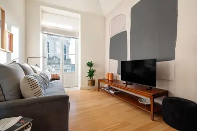 a living room with a couch and a flat screen tv at Liberty 119 • Luxurious 1BD in Porto's main Avenue in Porto