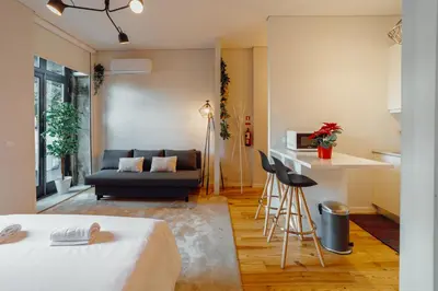 a living room with a bed and a couch at Apartamento Luminoso no Centro in Porto