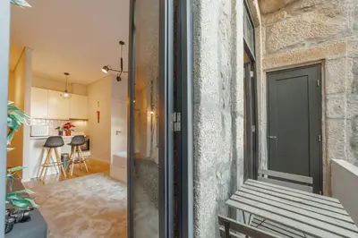 a room with a door and a bench next to a building at Apartamento Luminoso no Centro in Porto