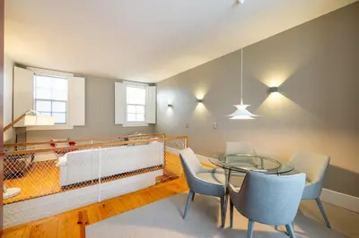 a dining room with a glass table and chairs at Casa do Ofício - Livreiro in Porto