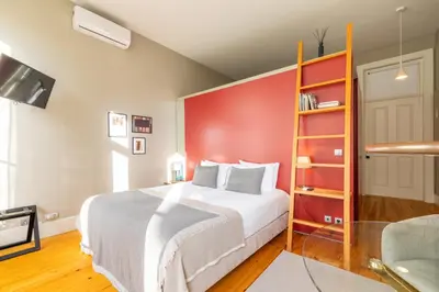 a bedroom with a large bed and a red wall at Casa do Ofício - Livreiro in Porto