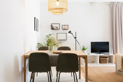 a dining room table with chairs and a television at VIVA Miragaia Downtown in Porto
