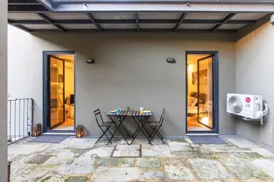 a patio with a table and chairs next to a building at Downtown Studio w/ AC & Patio by LovelyStay in Porto