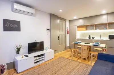 a living room with a kitchen and a desk with a tv at Downtown Studio w/ AC & Patio by LovelyStay in Porto