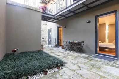 a patio with a table on the side of a house at Downtown Studio w/ AC & Patio by LovelyStay in Porto