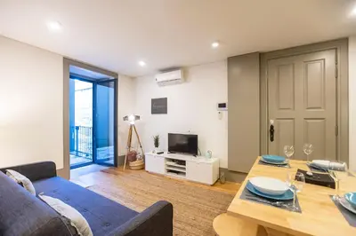 a living room with a blue couch and a table at Downtown Studio w/ AC & Patio by LovelyStay in Porto
