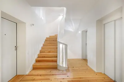 a staircase in a white room with wooden floors at InBloom Apartments 3 in Porto
