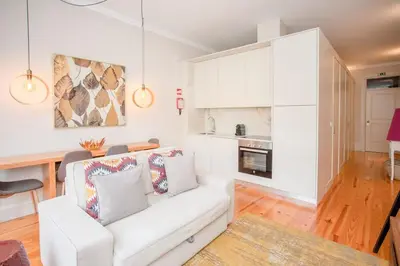 a living room with a white couch and a kitchen at Liiiving in Porto - Ribeira Secret Apartment in Porto