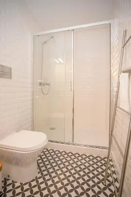 a bathroom with a shower with a toilet and a tiled floor at Liiiving in Porto - Ribeira Secret Apartment in Porto