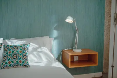 a bedroom with a bed with a lamp on a night stand at River Eyes Apartments in Porto