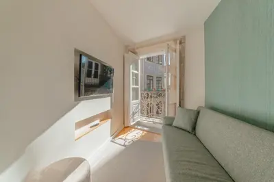 a living room with a green couch and a window at River Eyes Apartments in Porto