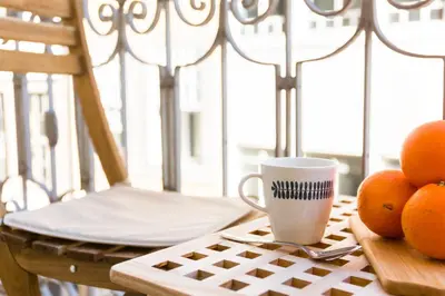 a cup of coffee and some oranges on a table at In Between Exclusive Charm Apartment by the center in Porto