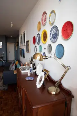 a table with a lamp and plates on a wall at Aconchegante Apartamento no Centro do Porto in Porto
