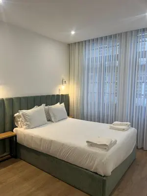 a bedroom with a bed with white sheets and a window at ORM- Flores Apartment in Porto