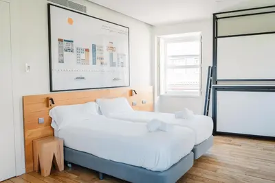 two beds in a room with a picture on the wall at The Central House Porto Ribeira in Porto