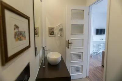 a bathroom with a bowl on a counter next to a door at Almada Studios & Suites in Porto
