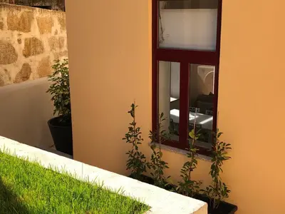a window on the side of a building with green grass at OPORTO WINE LOFTS in Vila Nova de Gaia
