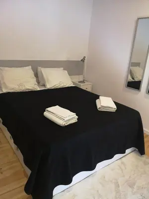 a bed with black sheets and white towels on it at OPORTO WINE LOFTS in Vila Nova de Gaia