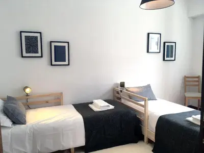 a bedroom with two beds and a table at PinPorto City Center III in Porto