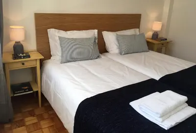 a bedroom with a large white bed with two night stands at PinPorto City Center III in Porto