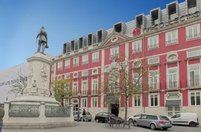 a pink building with a statue in front of it at Luxury Prime Batalha Apartments in Porto