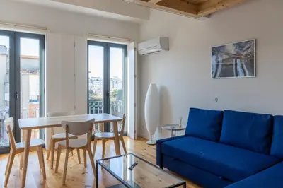 a living room with a blue couch and a table at Alvaro's Charming Loft by MP in Vila Nova de Gaia