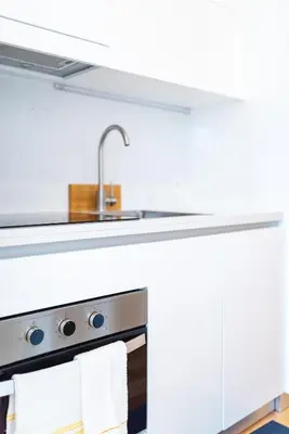 a kitchen with white cabinets and a sink at Alvaro's Charming Loft by MP in Vila Nova de Gaia