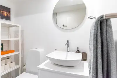 a white bathroom with a sink and a mirror at Alvaro's Charming Loft by MP in Vila Nova de Gaia