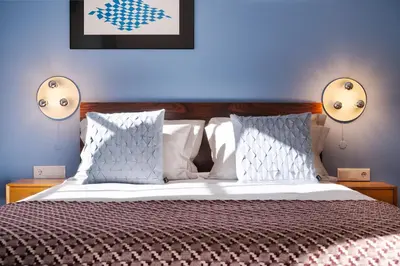 a bedroom with a bed with two lights on the wall at Blue Moon Studio in Porto